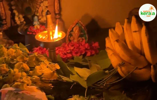 Vishu Kani arrangement with Konna flowers, mirror, fruits, vegetables, rice, and lit lamp for Kerala’s Vishu festival celebration.