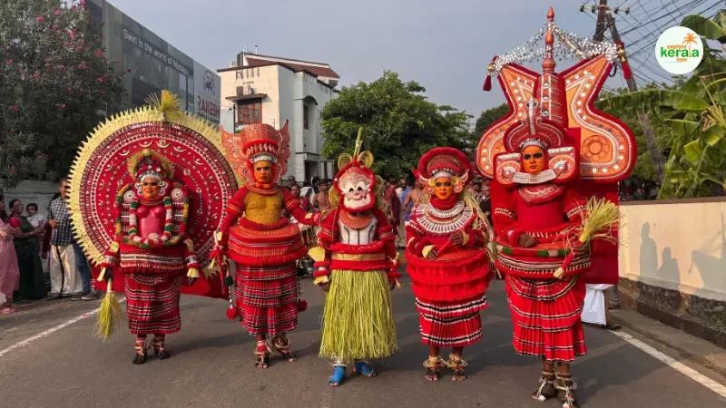 Performer dressed in elaborate red costume and face paint during a Theyyam ritual in North Kerala temple grounds.